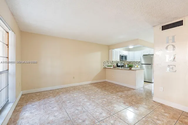 a view of kitchen with refrigerator and window