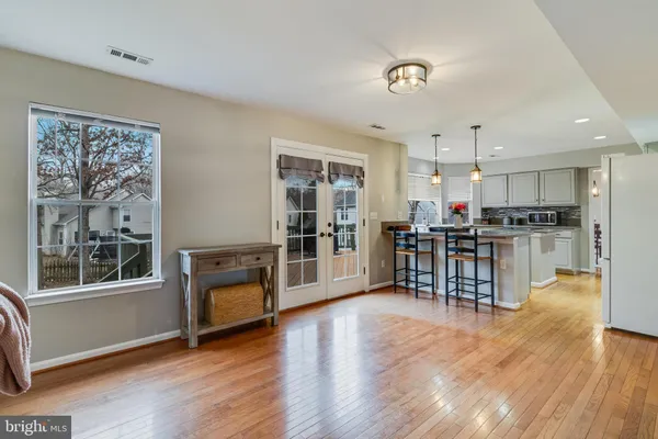 a kitchen with stainless steel appliances wooden floors and dining table
