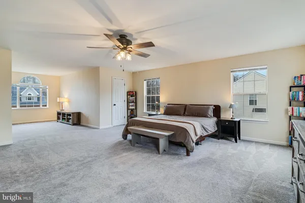 a spacious bedroom with a bed and a chandelier