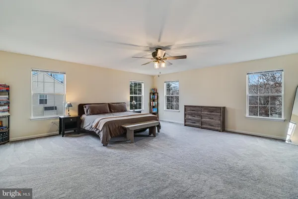 a spacious bedroom with a bed and a ceiling fan