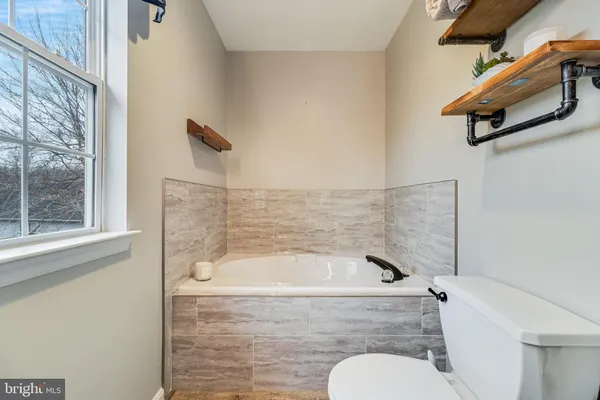 a bathroom with a tub and a window