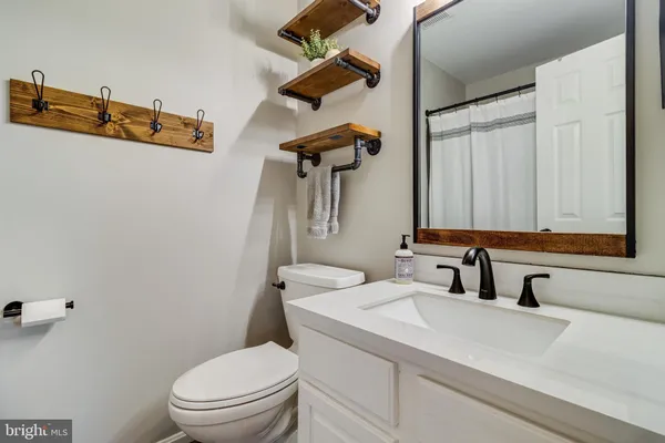 a bathroom with a sink vanity mirror and toilet
