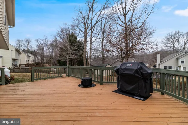 a view of roof deck with wooden floor and fence with a bench
