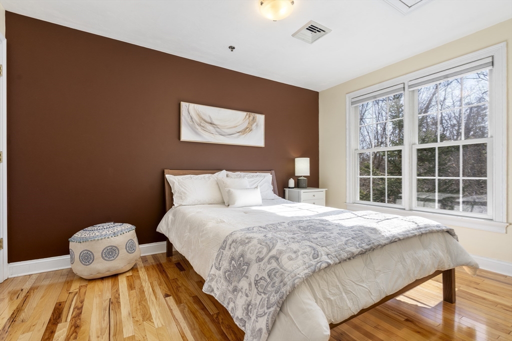 8 Brookside Lane, Unit 8 Northborough, MA 01532 - Photo 16 of 24 a bedroom with a bed and wooden floor
