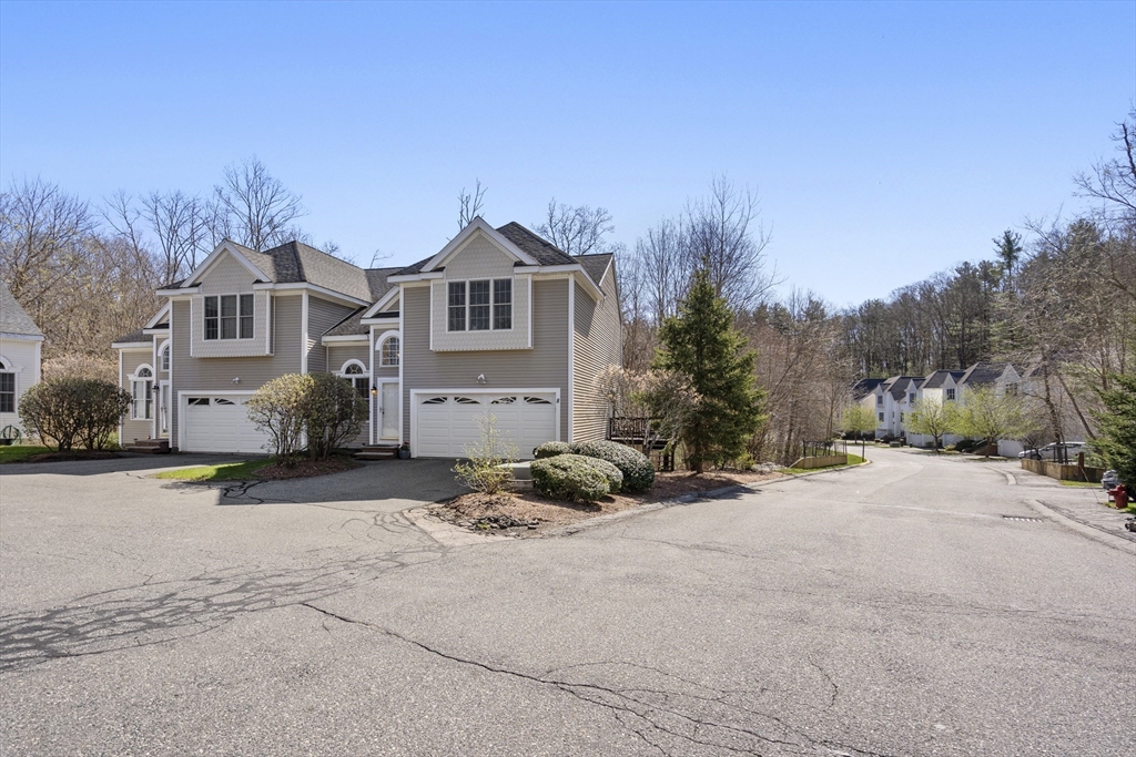 8 Brookside Lane, Unit 8 Northborough, MA 01532 - Photo 24 of 24 a front view of a house with a yard and garage