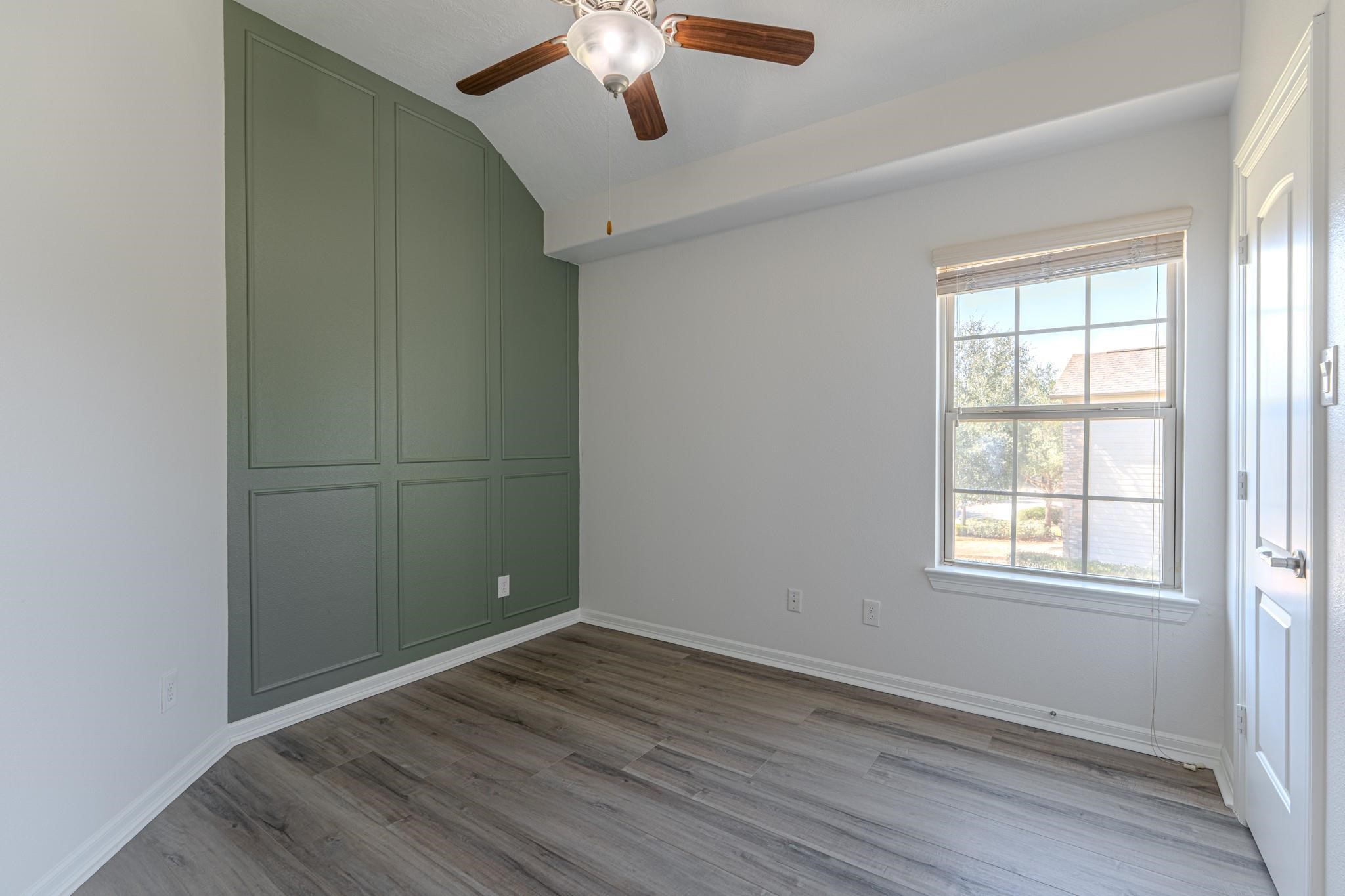 58 Aventura Place Spring, TX 77389 - Photo 18 of 23 an empty room with wooden floor cabinet and windows