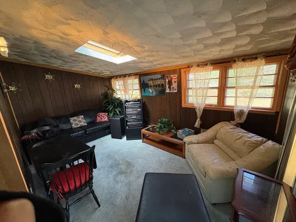 a living room with furniture fireplace and a large window