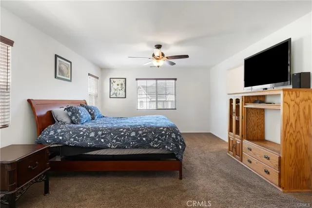 a bedroom with a bed and a flat tv screen on the dresser