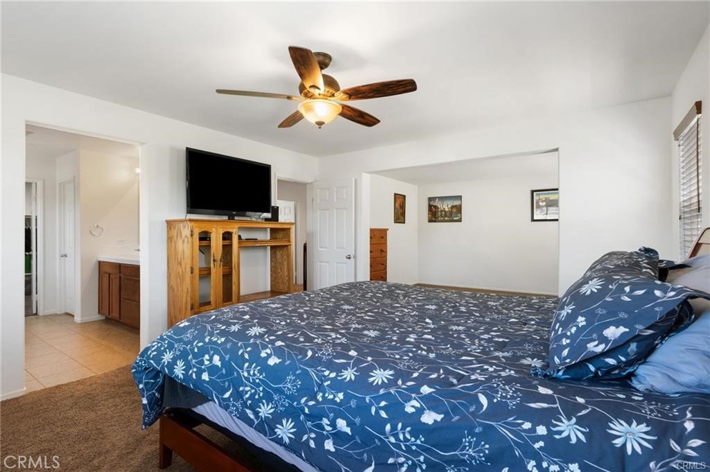 46545 Peach Tree Street Temecula, CA 92592 - Photo 18 of 30 a bedroom with a bed and a flat screen tv