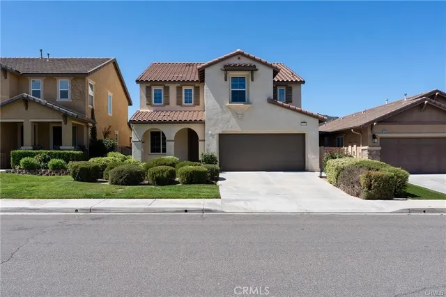 a front view of a house with a garden and plants