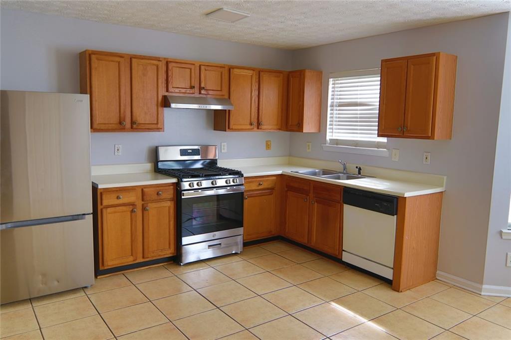 363 Springhaven Way Southeast Lawrenceville, GA 30046 - Photo 3 of 13 a kitchen with a stove sink and cabinets