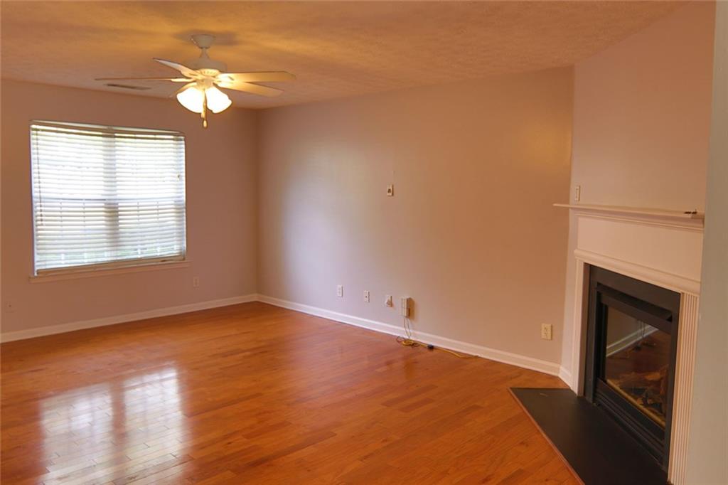 363 Springhaven Way Southeast Lawrenceville, GA 30046 - Photo 5 of 13 an empty room with wooden floor fireplace and windows