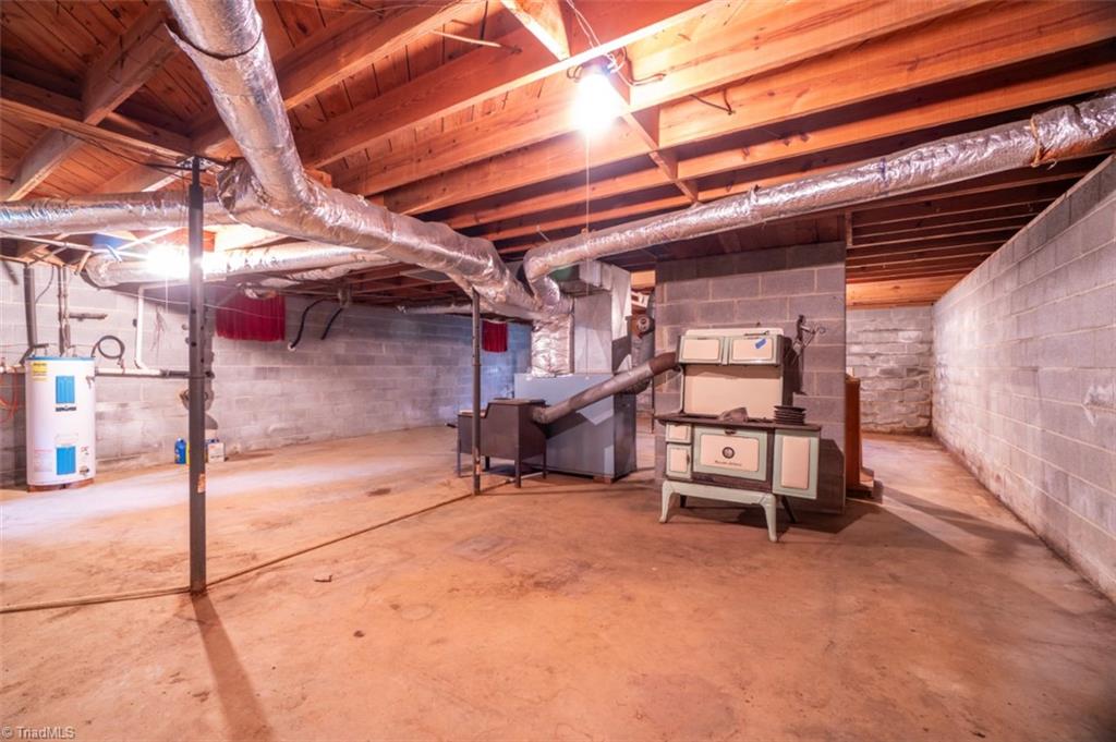 2449 Ralph Joyce Road Sandy Ridge, NC 27046 - Photo 23 of 30 Full Basement with wood stove / heat pump / oil furnace (cook wood stove not to remain)