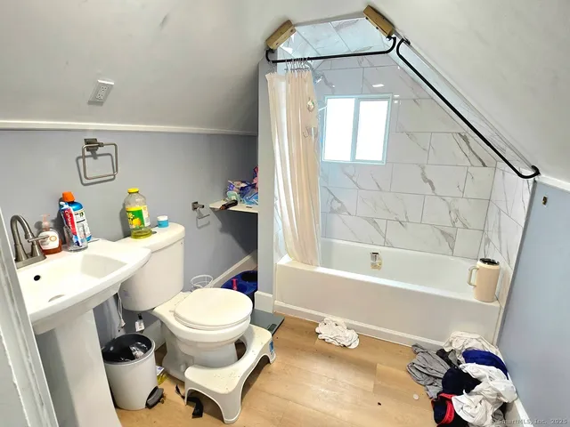 a white bath tub sitting next to a white toilet and sink