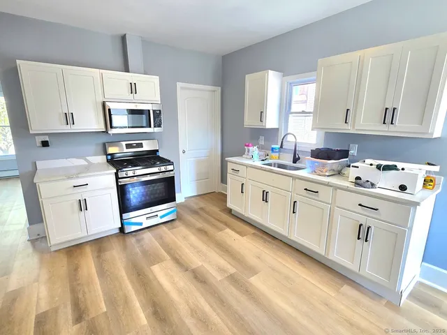 a kitchen with stainless steel appliances a white cabinets and sink