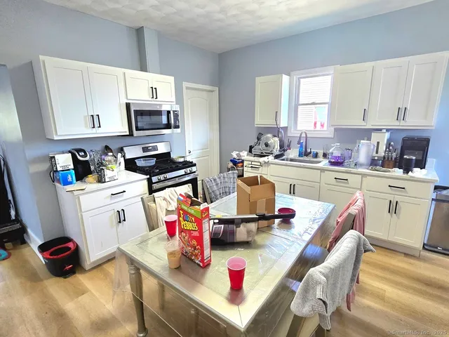 a kitchen with white cabinets and appliances