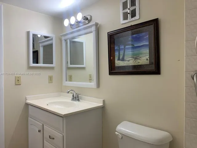 a bathroom with a toilet a sink and mirror