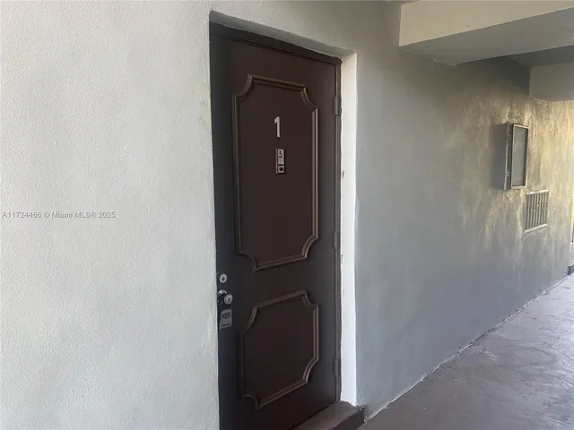 a view of a hallway with wooden cabinets