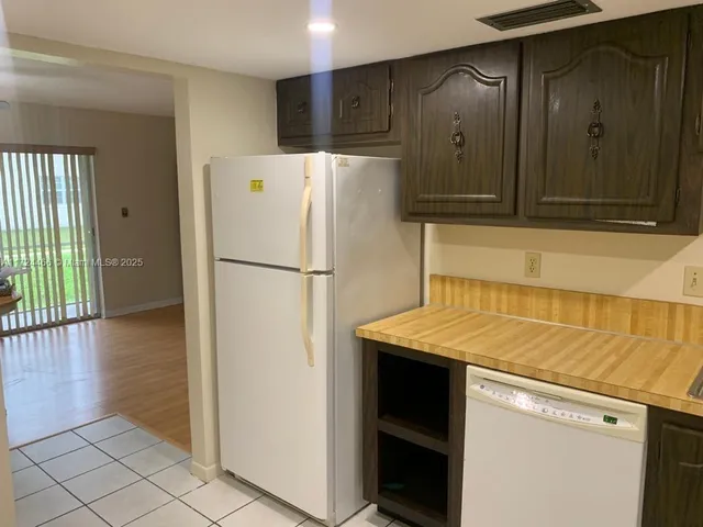 a white refrigerator freezer and a stove sitting inside of a kitchen