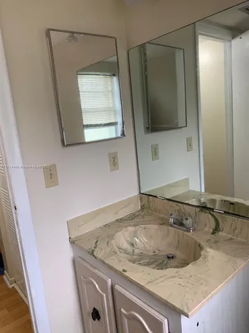 a bathroom with a granite countertop sink and mirror