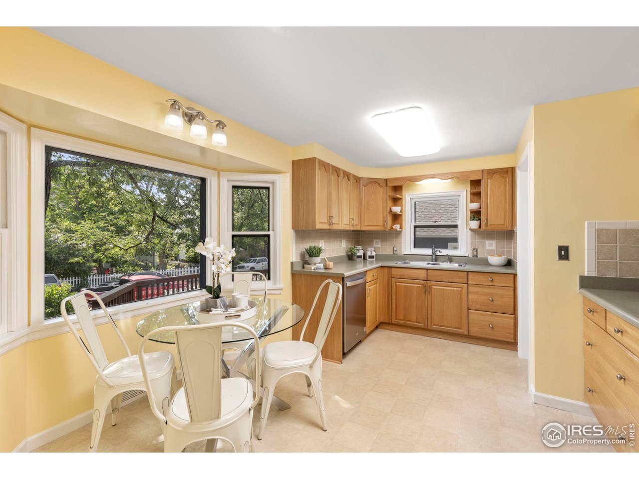 441 Sumner Street Longmont, CO 80501 - Photo 12 of 34 a kitchen with a table chairs refrigerator and cabinets