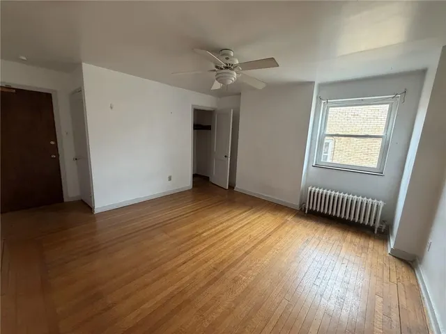 wooden floor in an empty room with a window