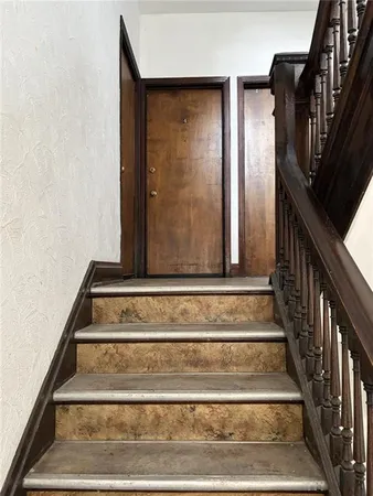 a view of staircase with white walls and railing