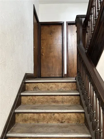 a view of staircase with white walls and railing