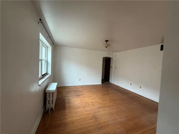 a view of room with window and wooden floor