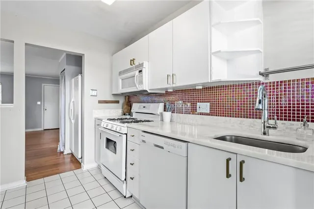 a kitchen with granite countertop white cabinets and white appliances