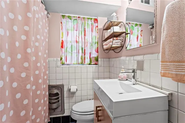 a bathroom with a sink a toilet and a mirror