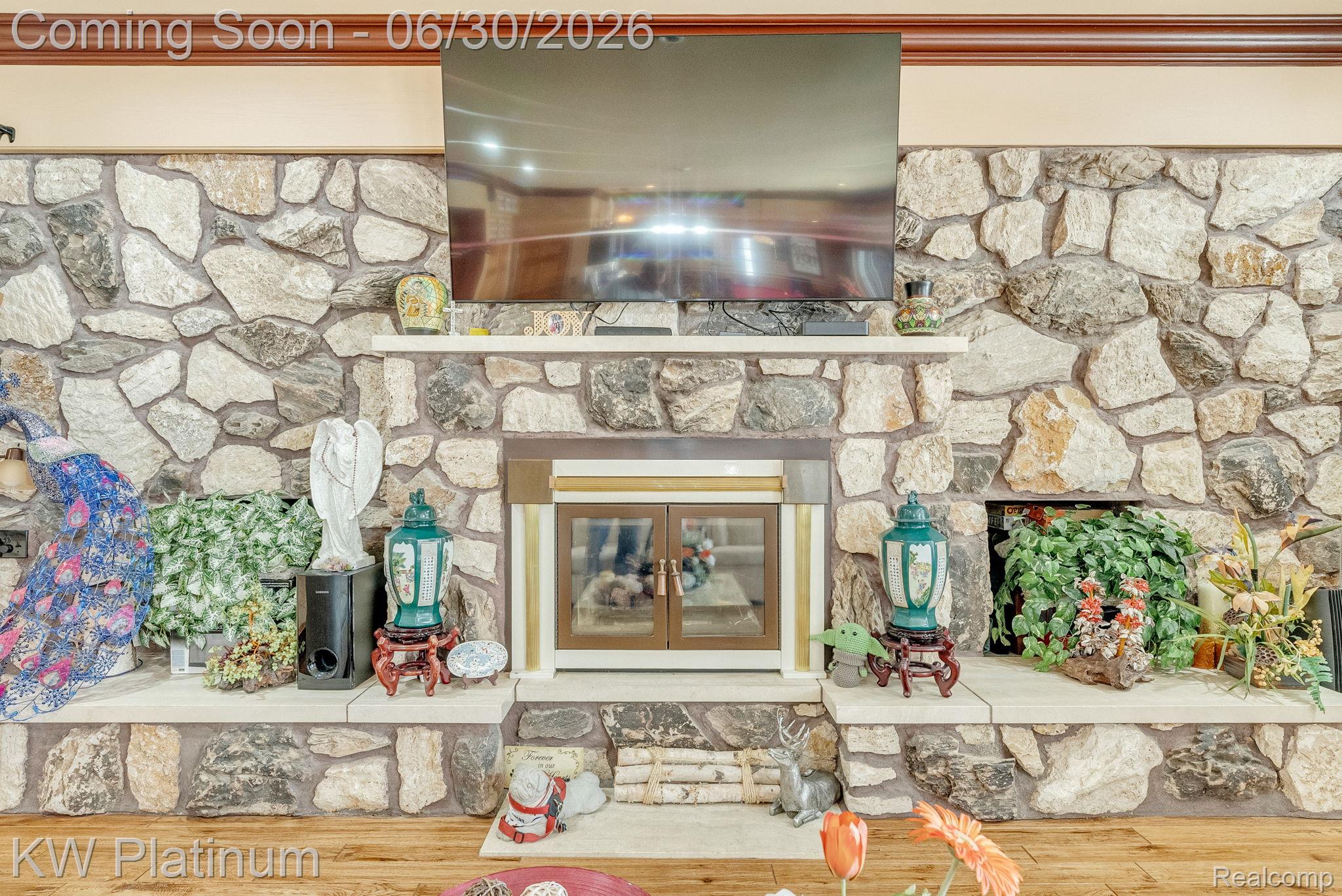 2235 South Lake Shore Road Harbor Beach, MI 48441 - Photo 18 of 99 Full-height stone fireplace featuring a wood-burning insert with glass doors, a stone hearth, and an integrated mantel