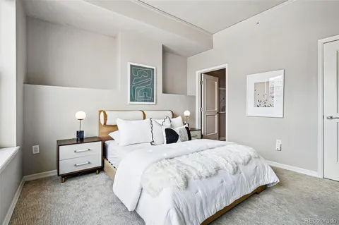 a bedroom with a bed and a night stand