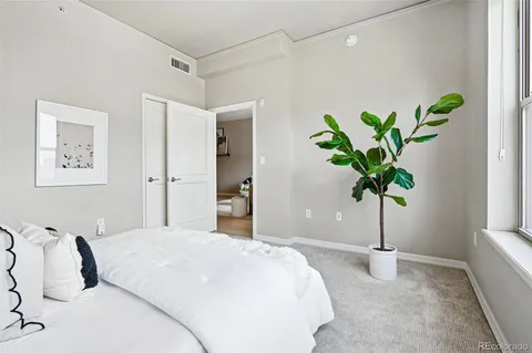 a bedroom with a bed and a potted plant
