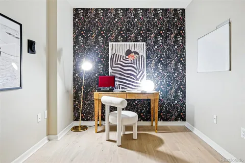 a hallway with wooden floor and a potted plant