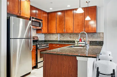 a kitchen with stainless steel appliances granite countertop a refrigerator and a sink