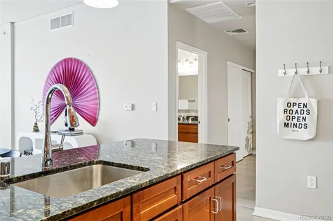 a kitchen with a sink granite counter tops and a wooden floor