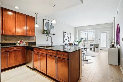 a kitchen with stainless steel appliances granite countertop a sink a stove and a wooden floors