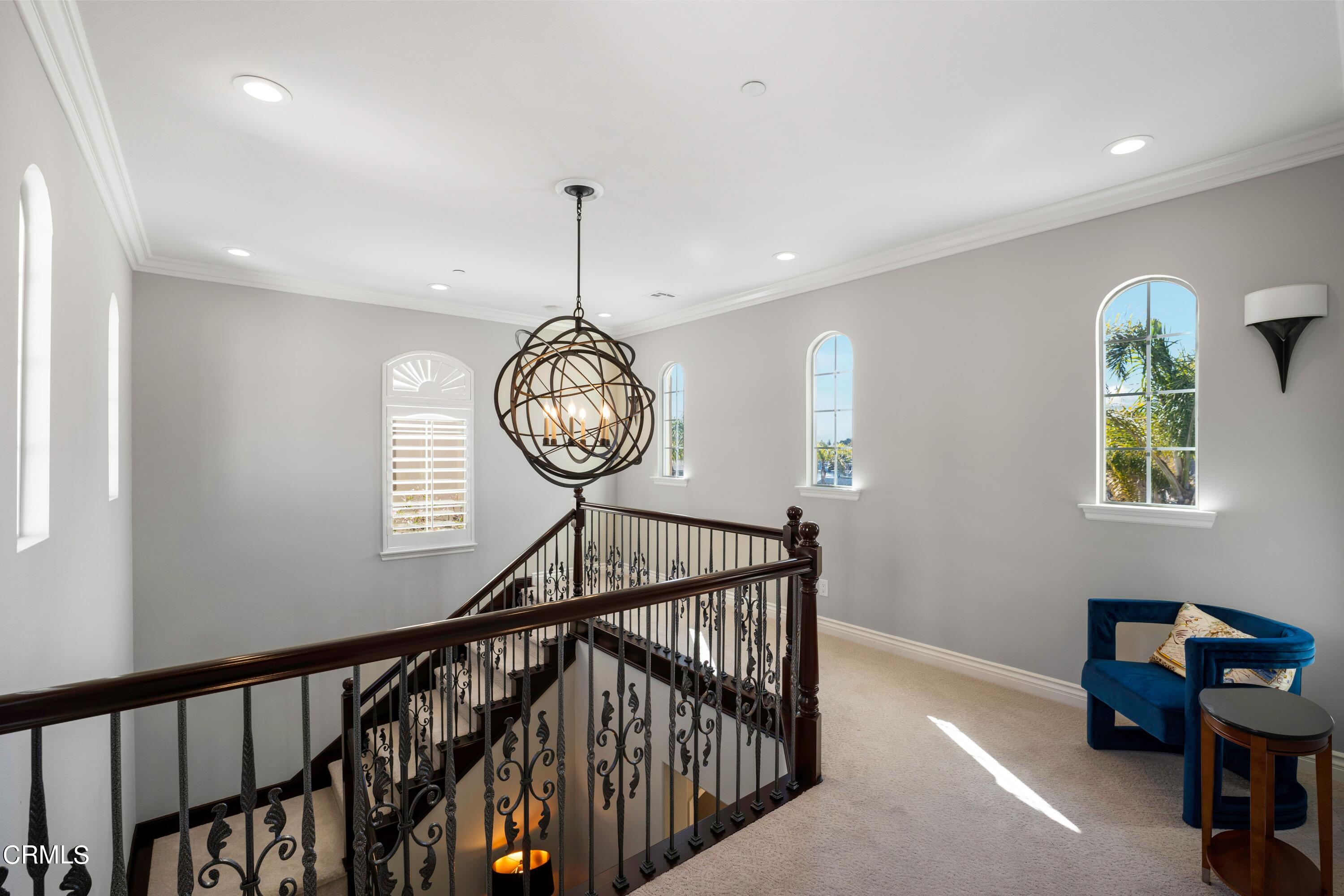 1544 Twin Tides Place Oxnard, CA 93035 - Photo 24 of 49 a view of staircase with a table and a chandelier