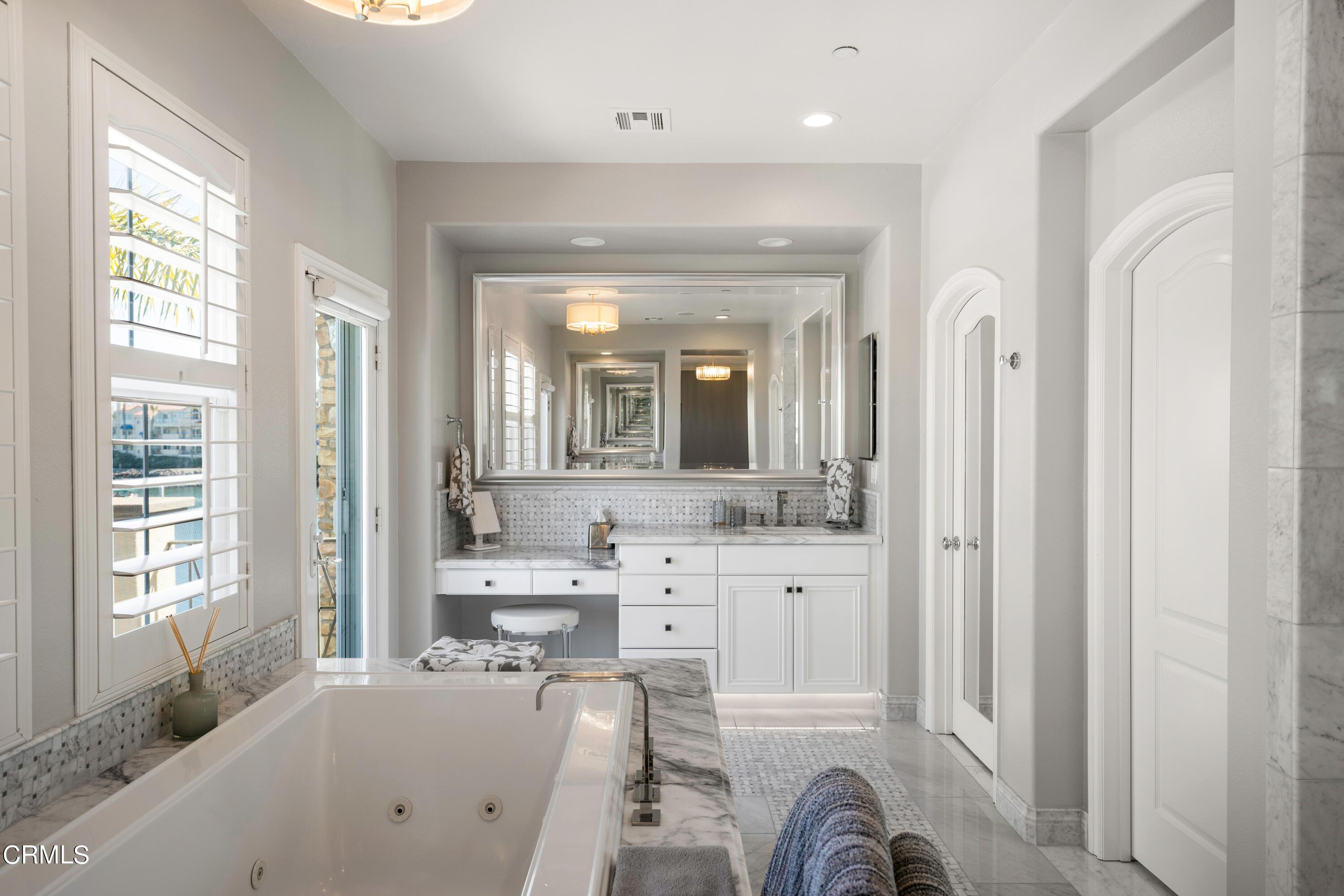 1544 Twin Tides Place Oxnard, CA 93035 - Photo 29 of 49 a large bathroom with a tub a double vanity sink a mirror a window and a shower