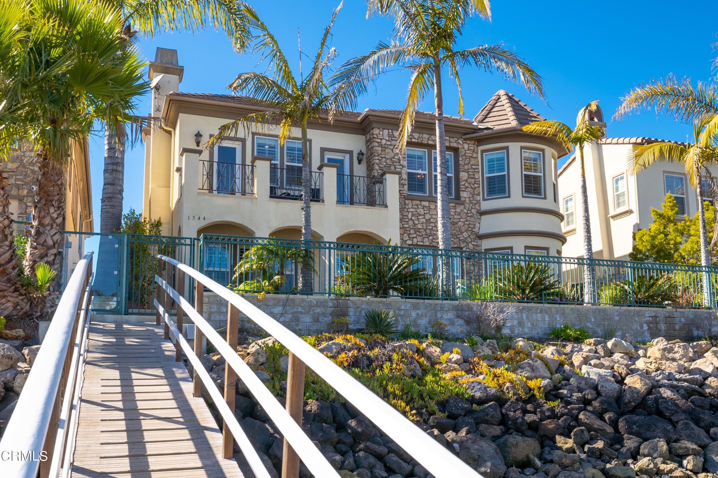 1544 Twin Tides Place Oxnard, CA 93035 - Photo 49 of 49 a front view of a house with a yard and potted plants