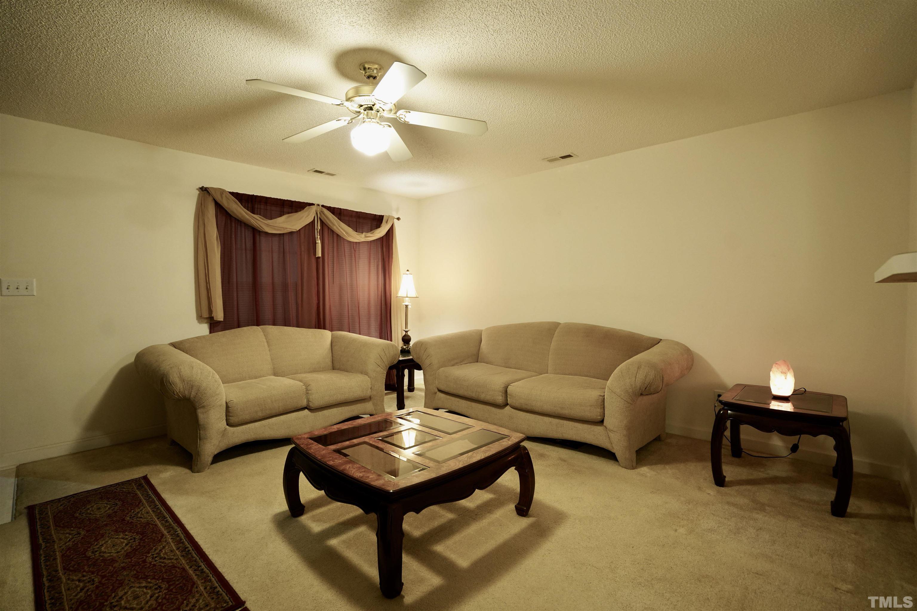 5102 Twisted Willow Way Raleigh, NC 27610 - Photo 2 of 12 a living room with furniture and a lamp