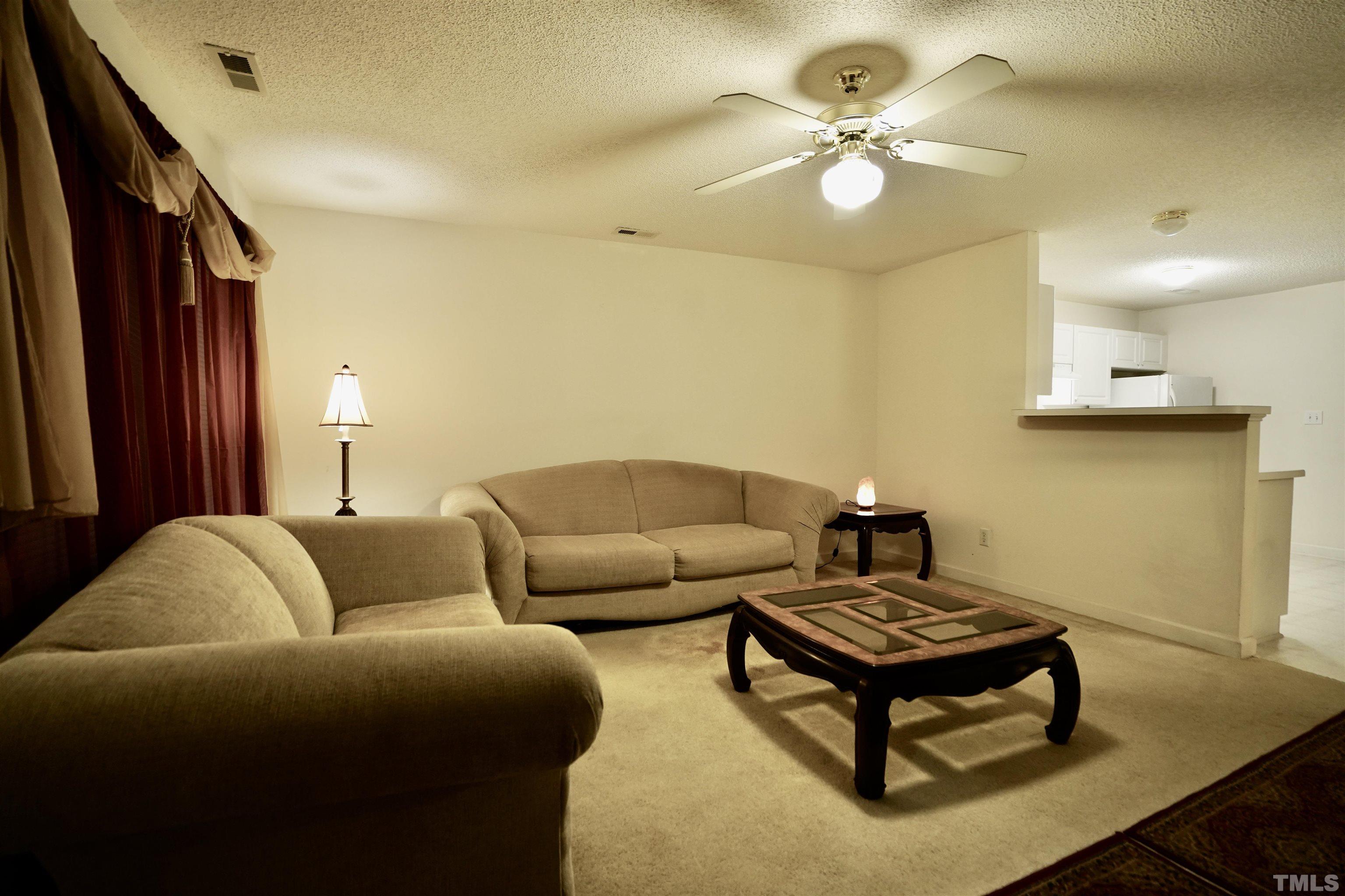 5102 Twisted Willow Way Raleigh, NC 27610 - Photo 3 of 12 a living room with furniture and a chandelier