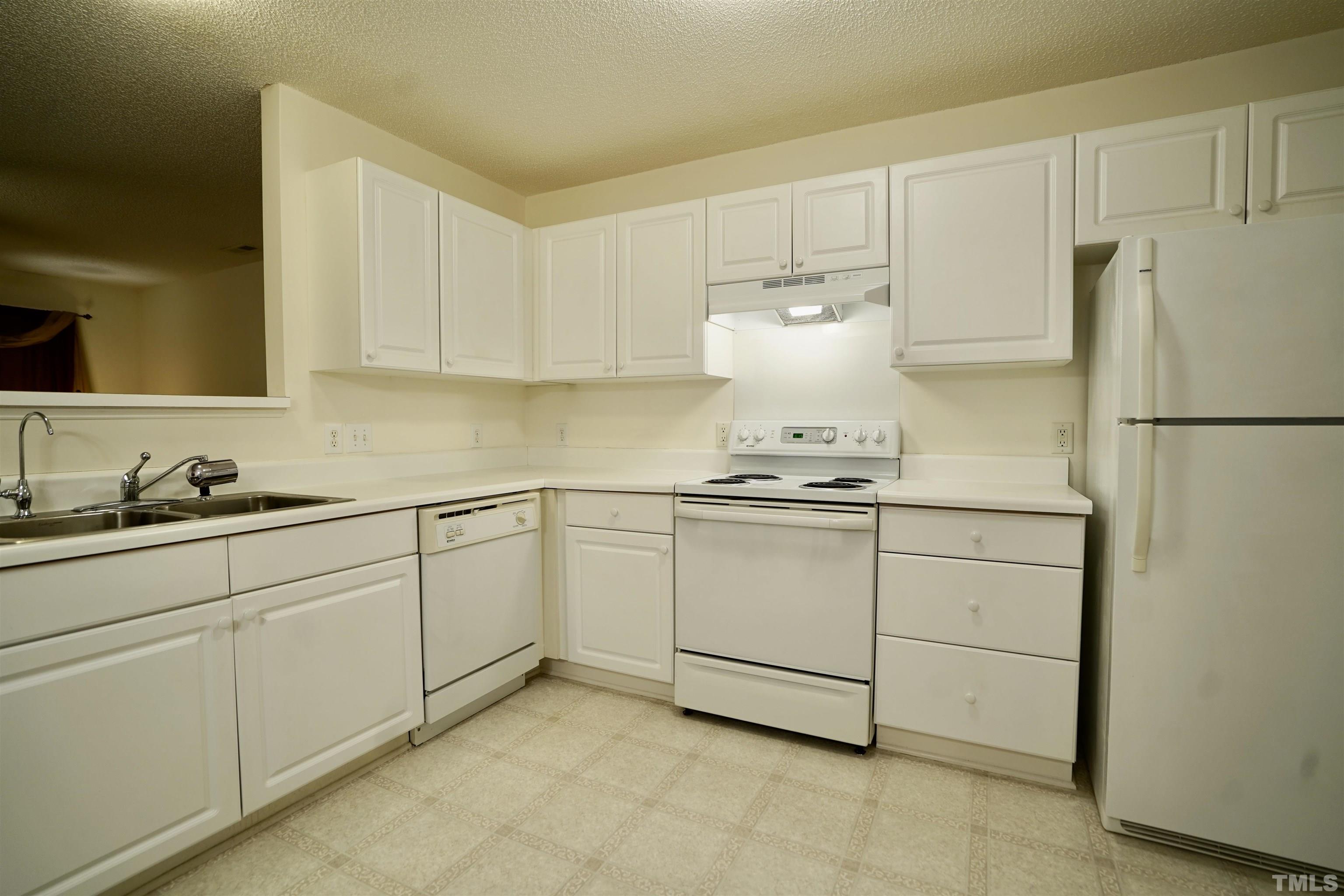 5102 Twisted Willow Way Raleigh, NC 27610 - Photo 4 of 12 a kitchen with white cabinets and white appliances