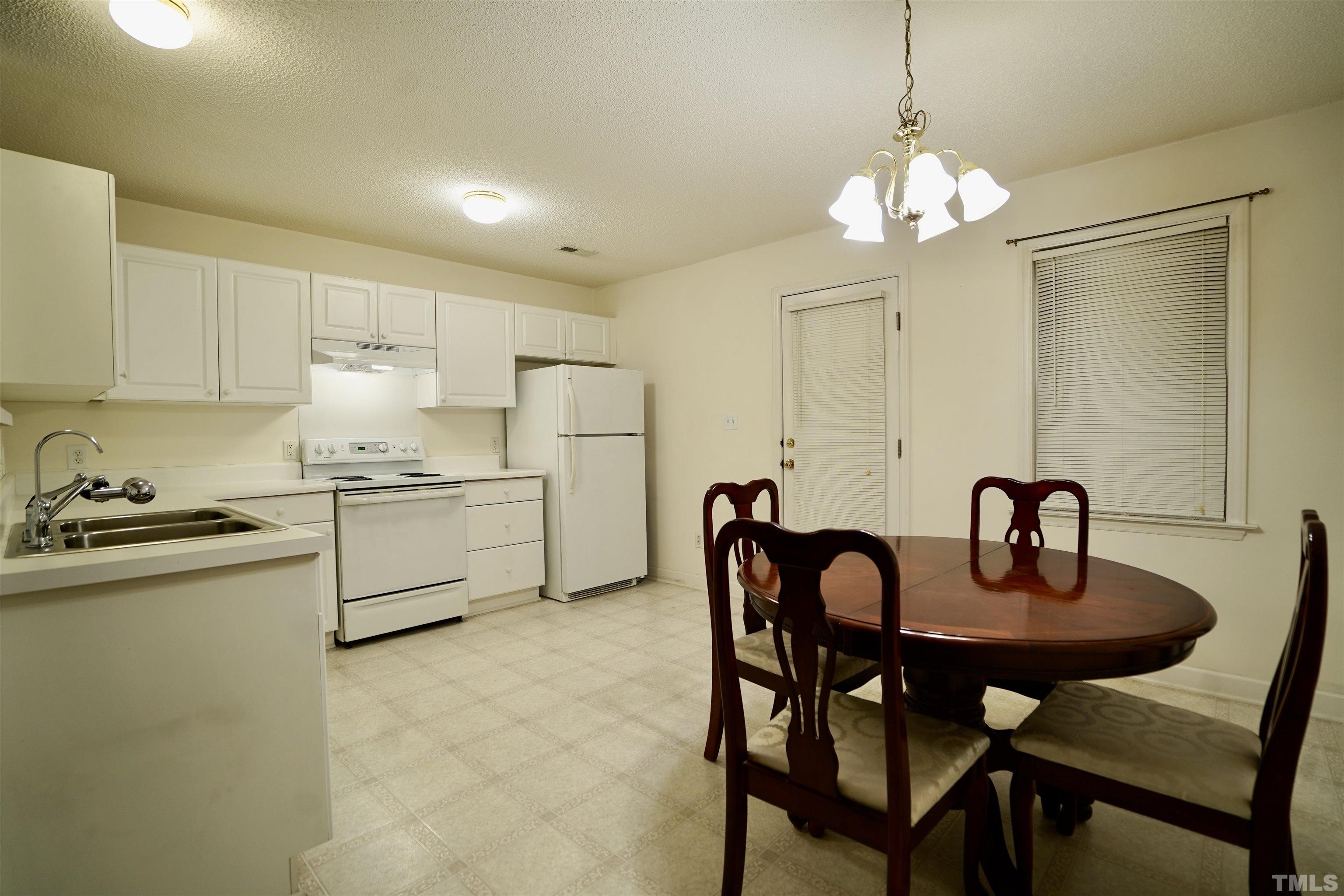5102 Twisted Willow Way Raleigh, NC 27610 - Photo 5 of 12 a kitchen with granite countertop a table and chairs