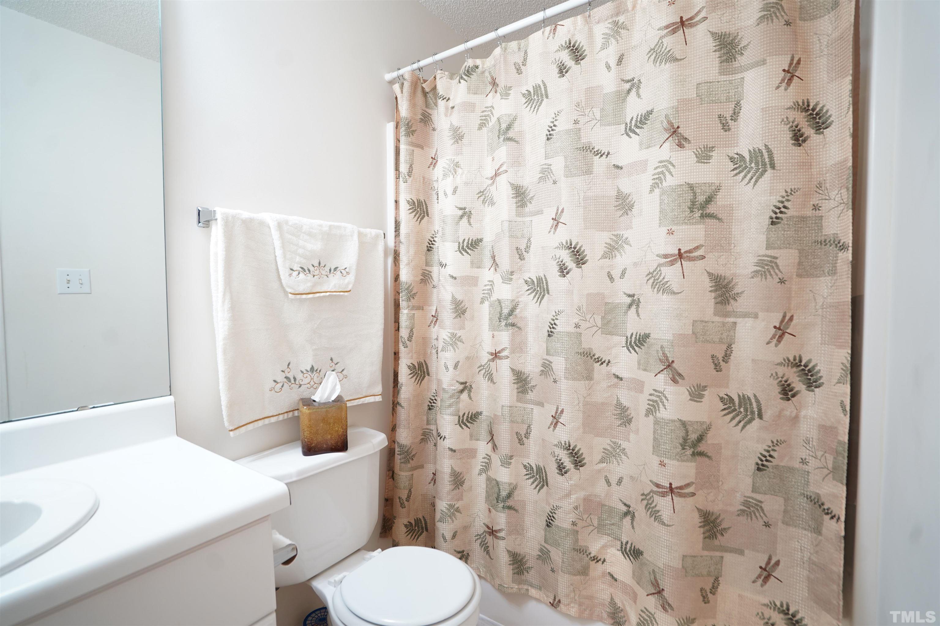 5102 Twisted Willow Way Raleigh, NC 27610 - Photo 10 of 12 a white toilet sitting next to a shower curtain