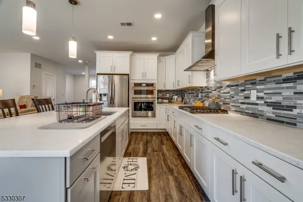 a large kitchen with stainless steel appliances kitchen island granite countertop a sink and cabinets