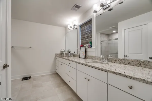 a bathroom with a granite countertop sink mirror and double