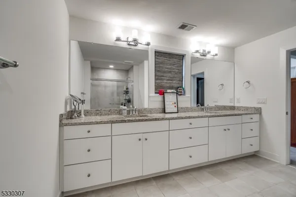 a bathroom with double sink and a mirror