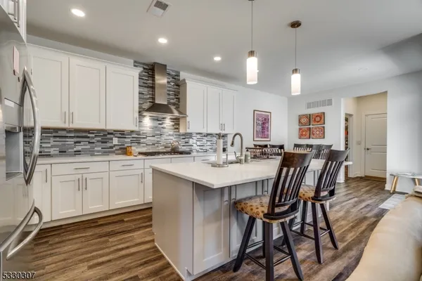 a kitchen with kitchen island granite countertop a sink and white cabinets